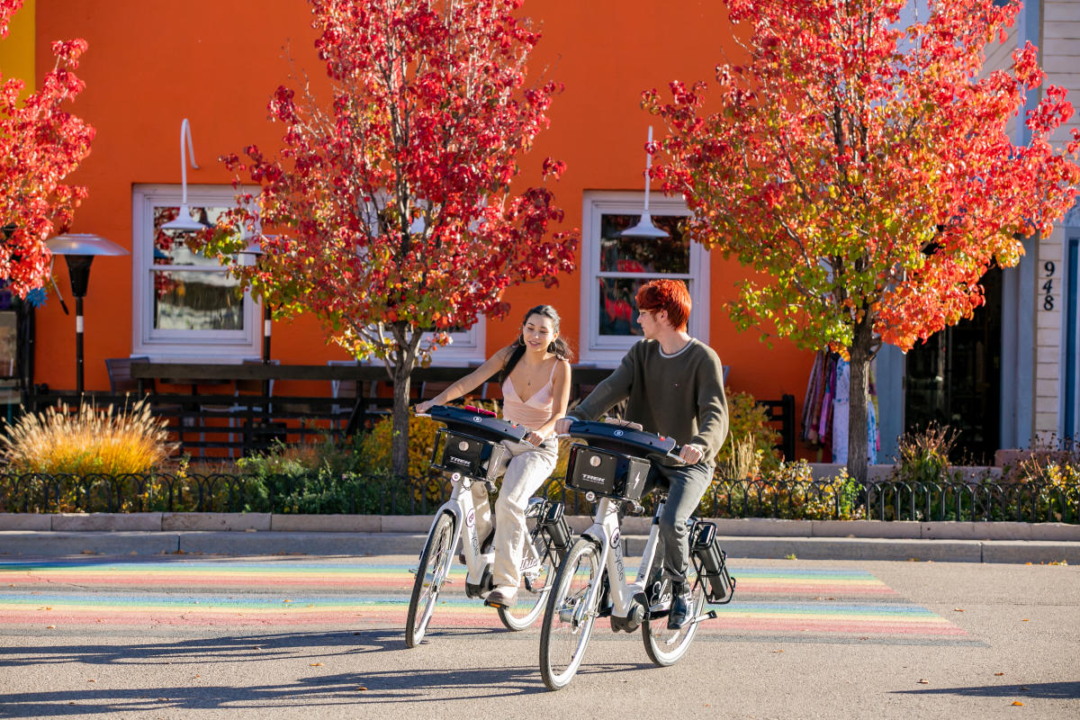 Two People Riding Bcycles in Fall