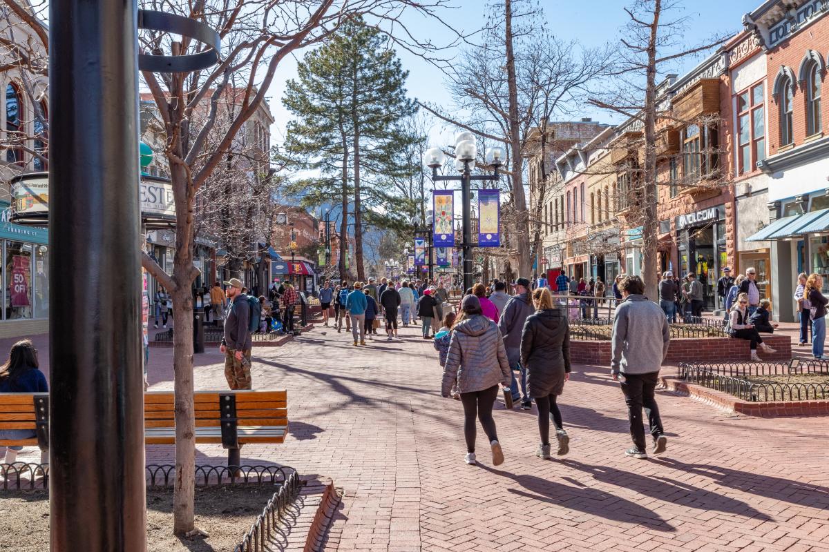 A sunny winter scene on Pearl Street with people walking on the brick-lined sidewalk on a sunny day