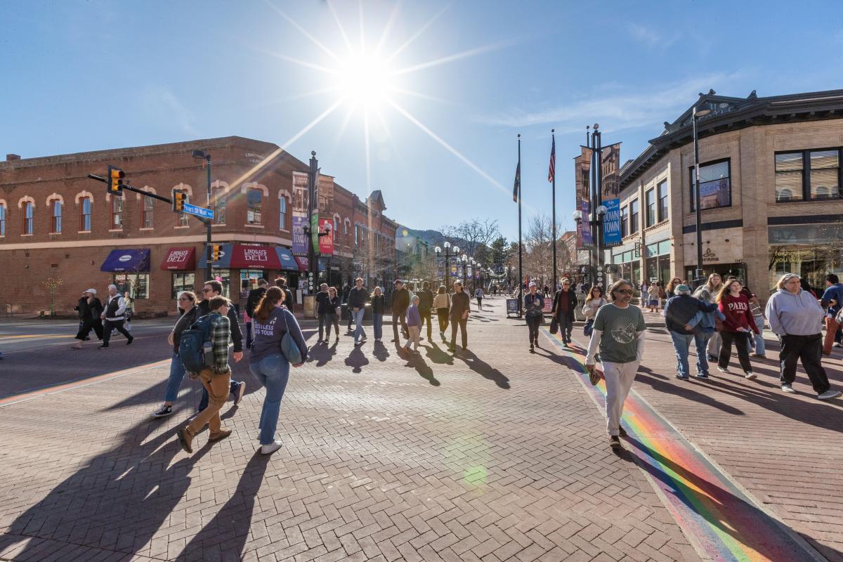 Pedestrians cross Broadway and Pearl Street on a sunny winter day in Boulder, CO