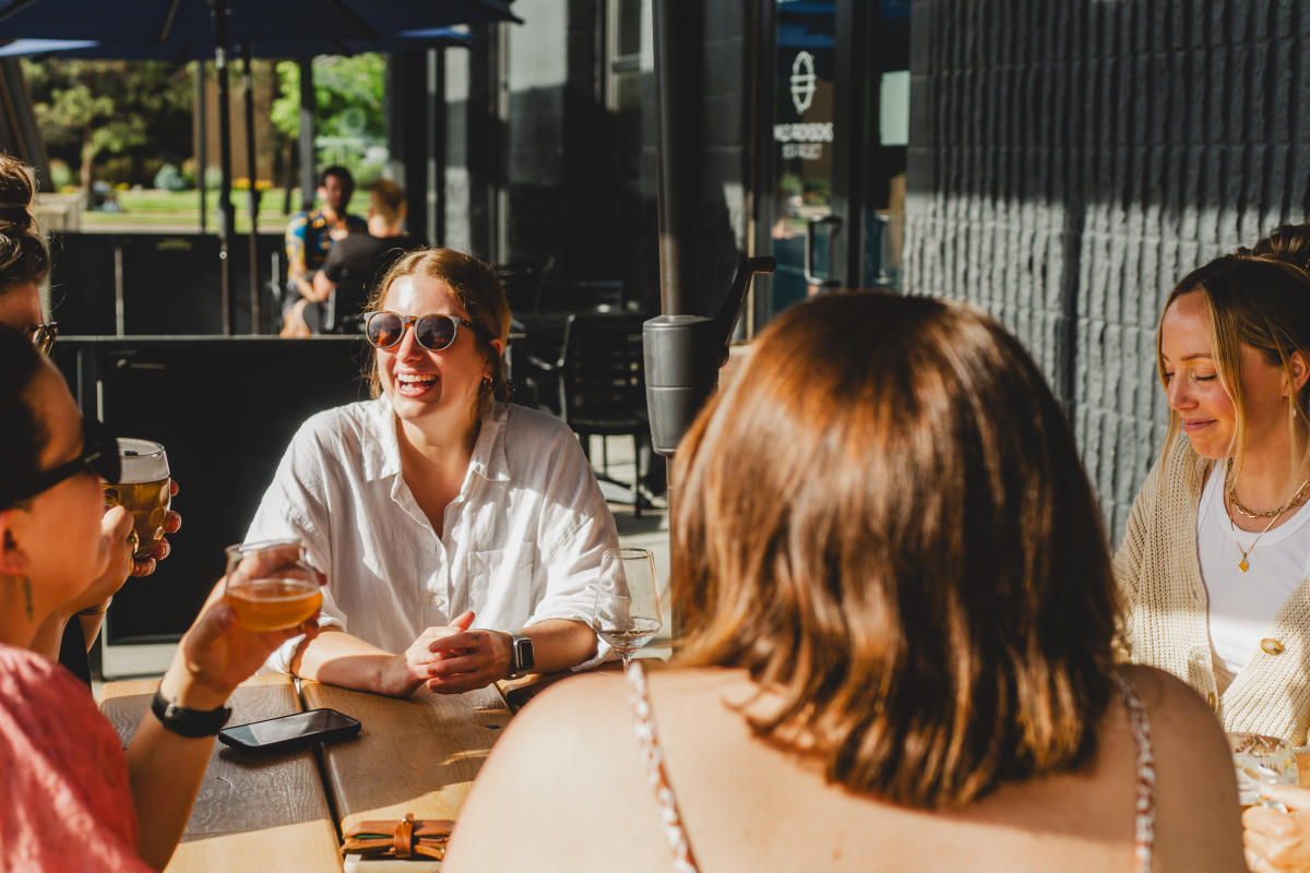 Wild Provisions Brewery Group Sitting Outside on Patio with Beer