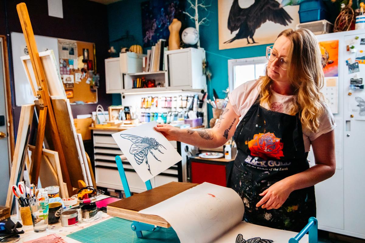 Artist pulling a bee print off a press