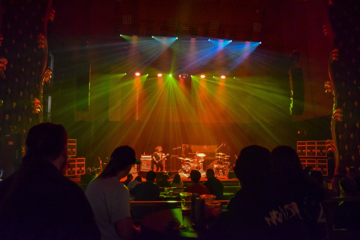 Audience enjoying a live music performance under vibrant stage lights at The Lincoln Theater in Cheyenne.