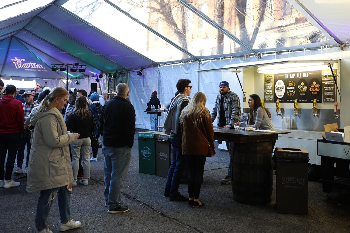 People lined up in a tent labelled Braxton Brewing at a bar waiting for Dark Charge beer