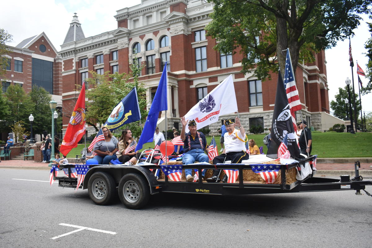 veterans and supporters ride float with flags during parade