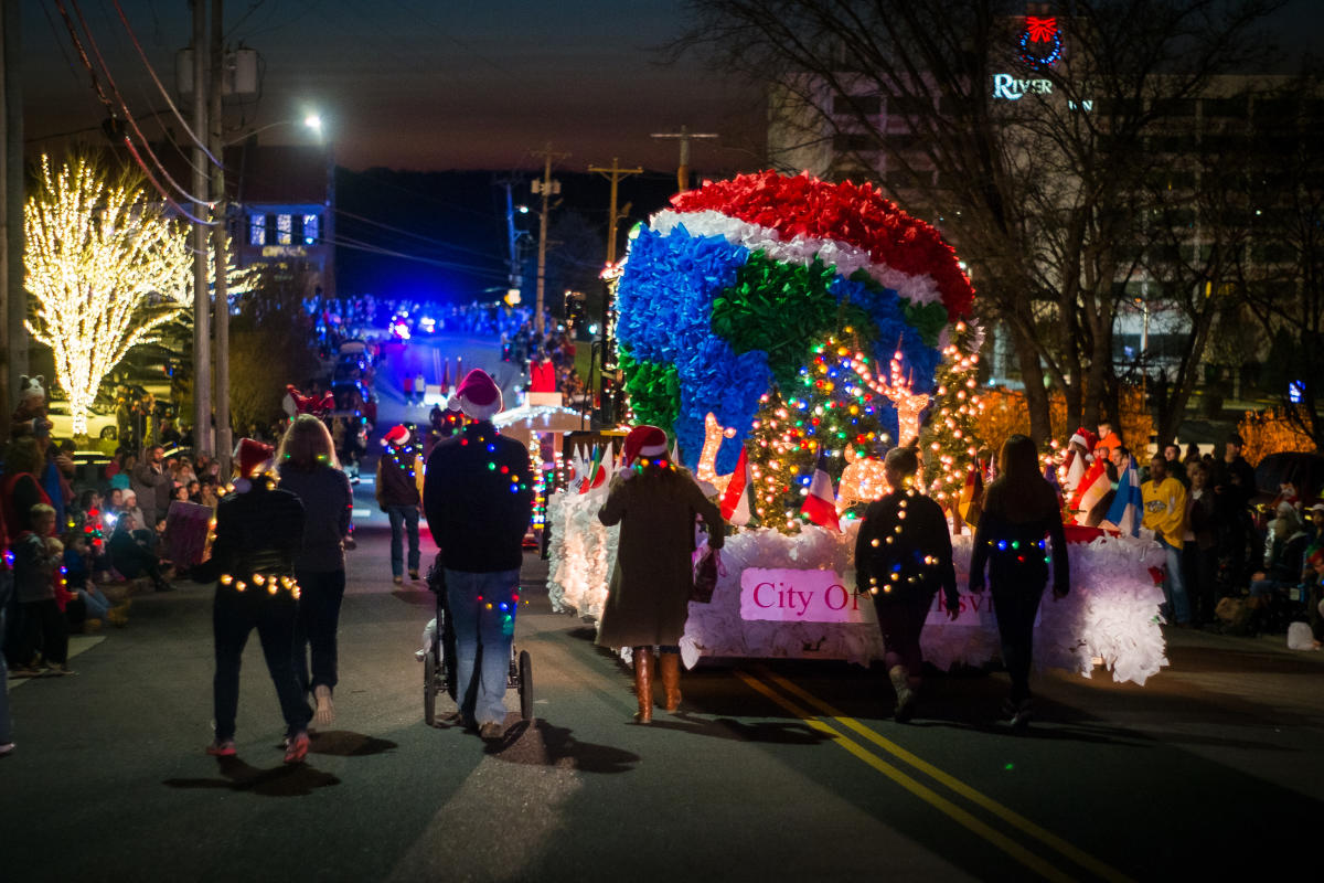 people walk with float during Christmas Parade