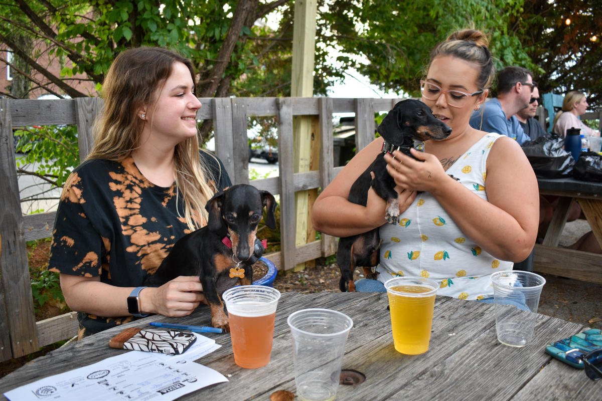 girls outside with beer and puppies