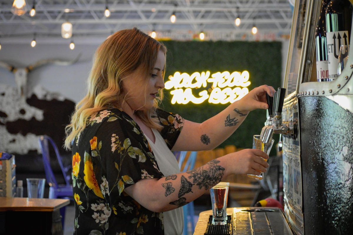a woman gets beer from a draft