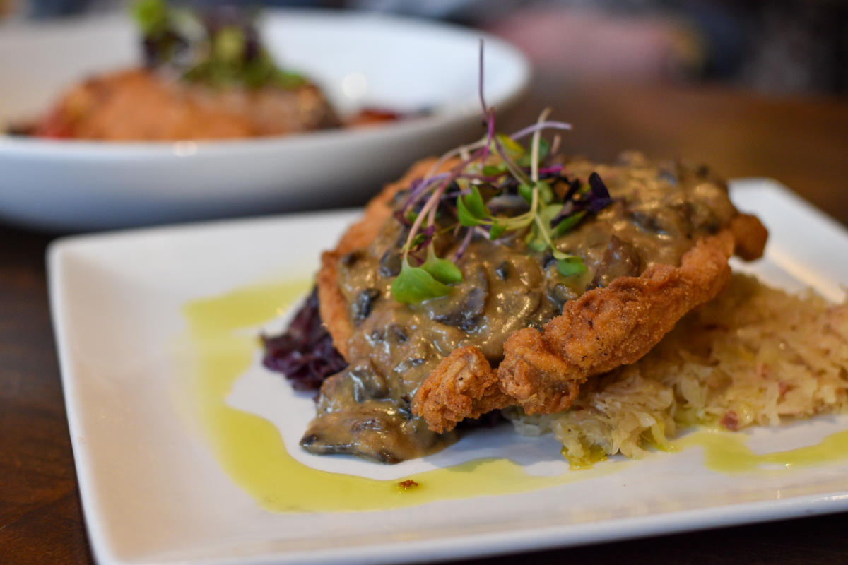 gravy-covered schnitzel on a plate