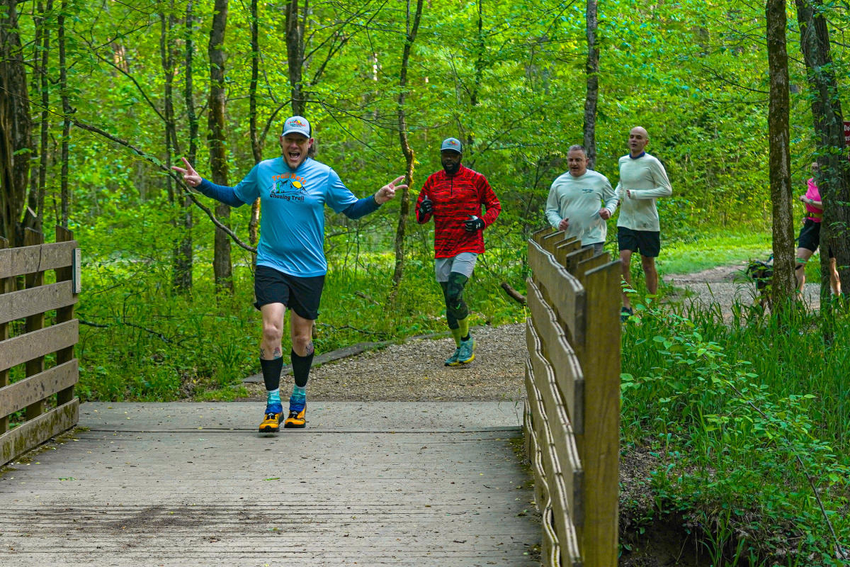 men running on a wooded trail