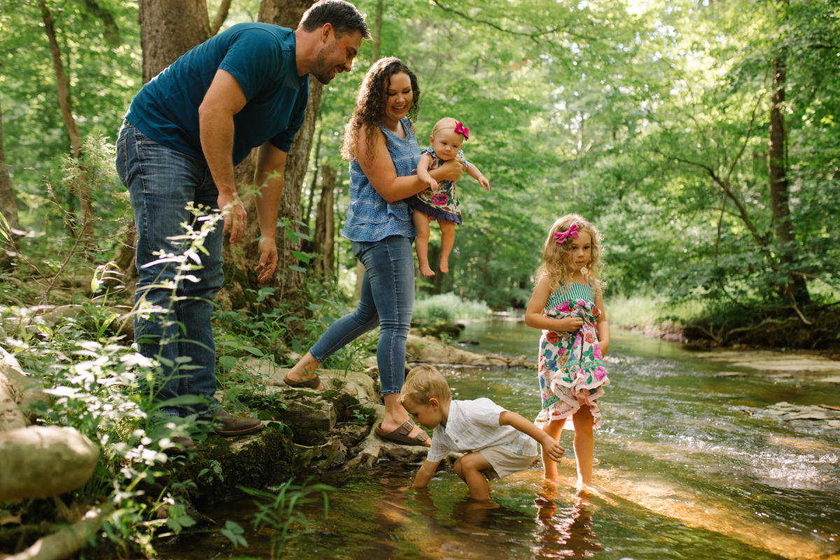 family playing in a creek