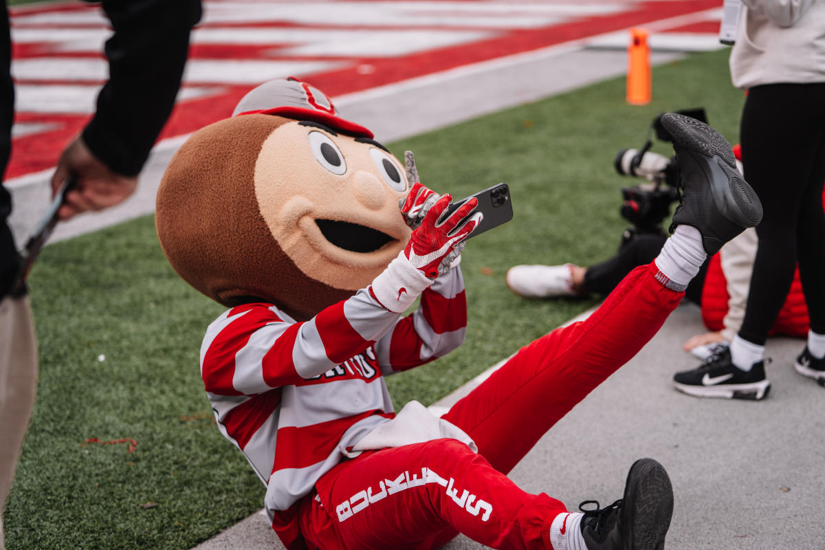 Brutus Buckeye taking a selfie on the football field