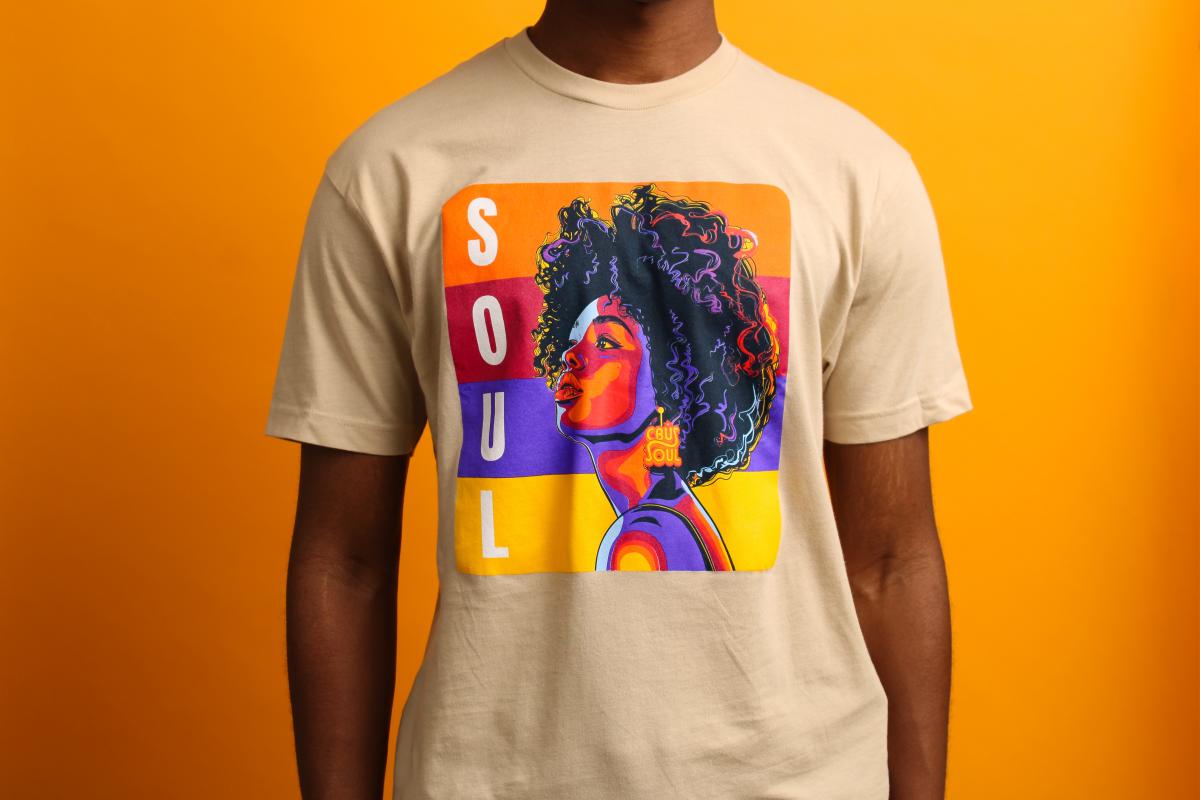 Black woman side profile with the colorful word "SOUL" aligned vertically on a tan t-shirt
