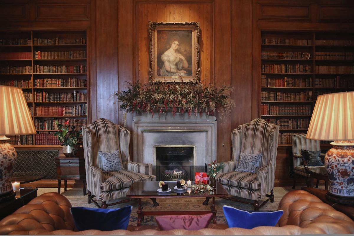 Grand fireplace with arm chairs and mugs of mulled wine