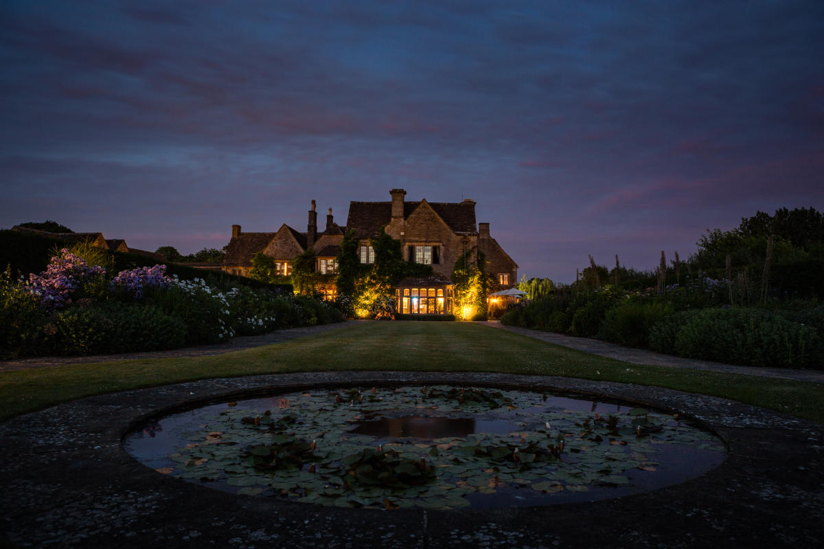 Lights glow from Whatley Manor as dusk sets in