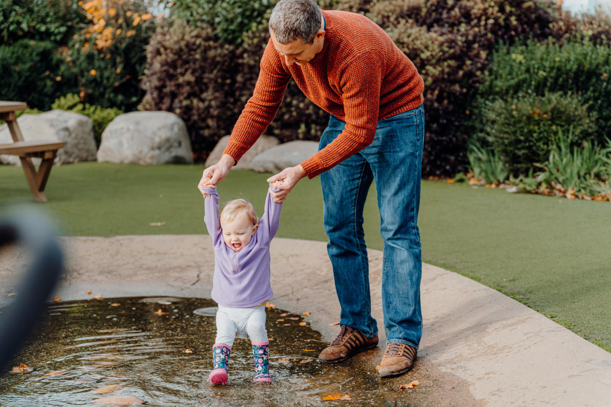 Father and daughter playing in a pond at Welly Boot Land in WWT Slimbridge