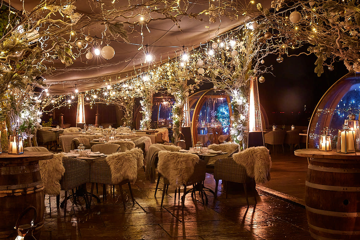 Decorated New Years Eve restaurant with sheeps wool blankets over the back of chairs and fairy lights lights