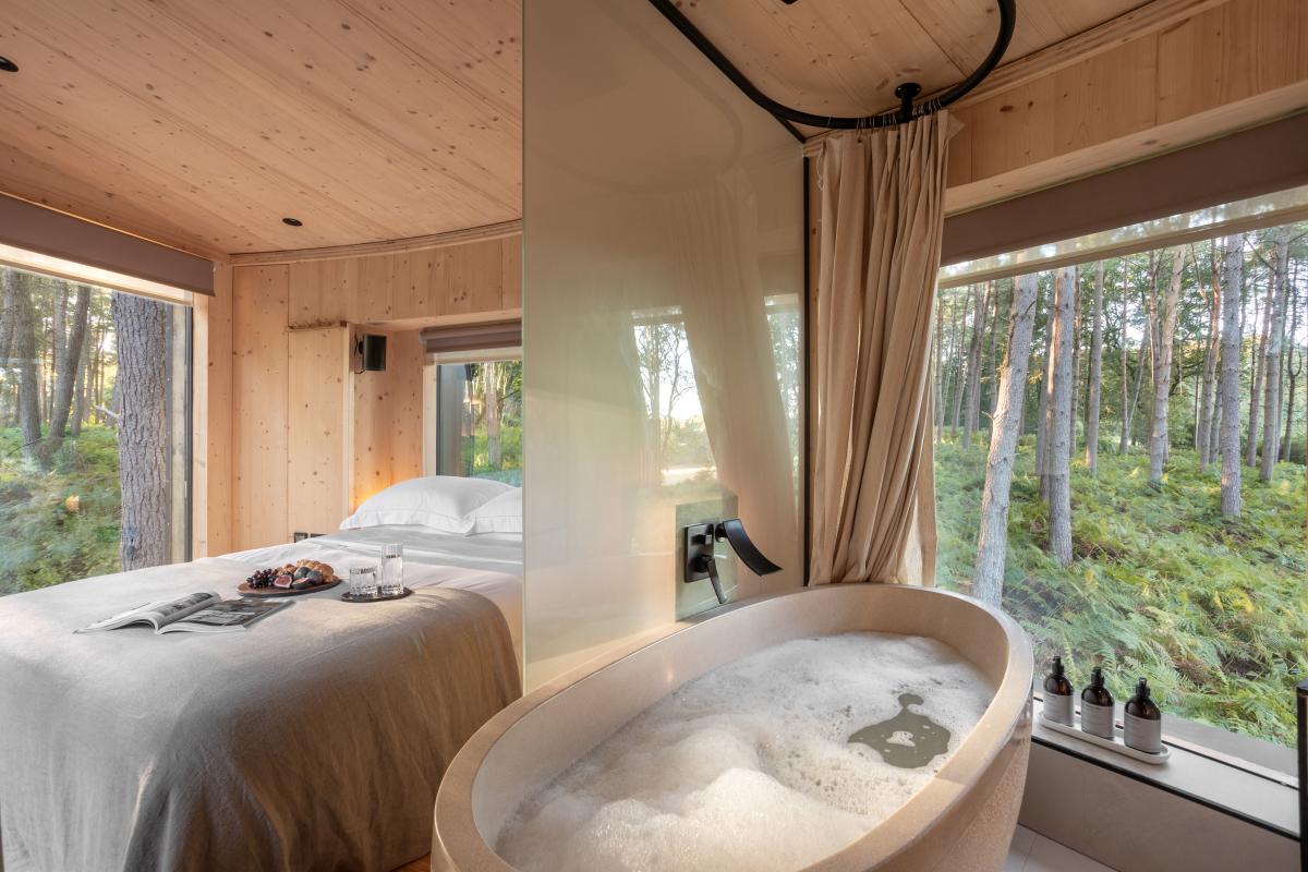 Inside of a TreeDweller tree house featuring bath and bed