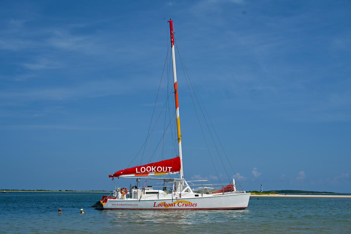 Lookout Catamaran Anchored with Lighthouse in Background