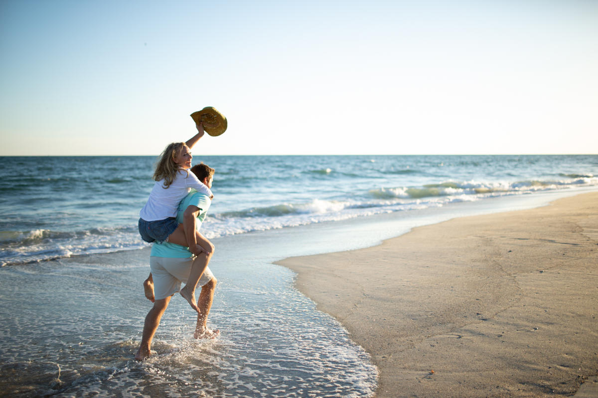 couple piggyback riding on the beach