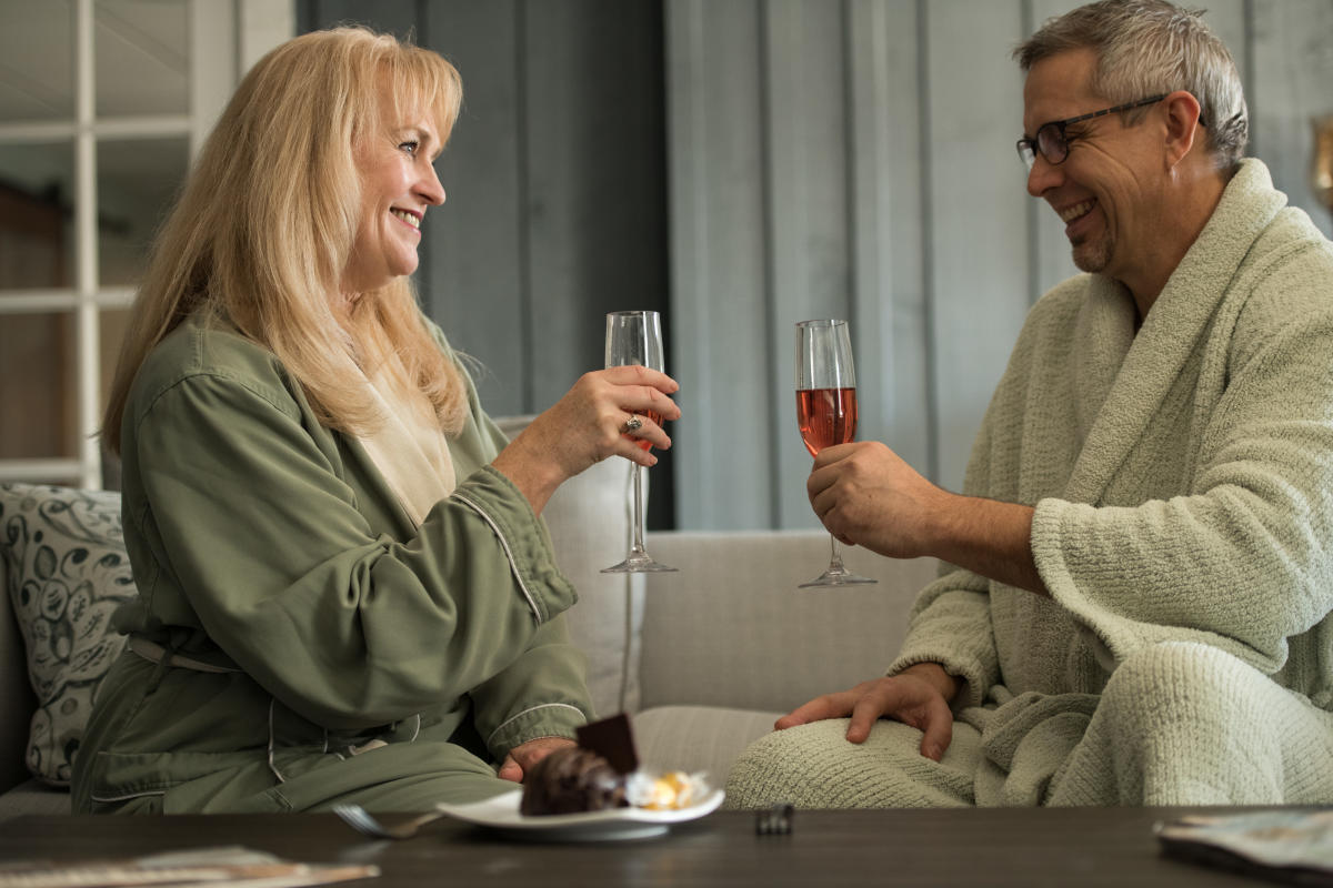 Couple drinking wine in bed an breakfast suite