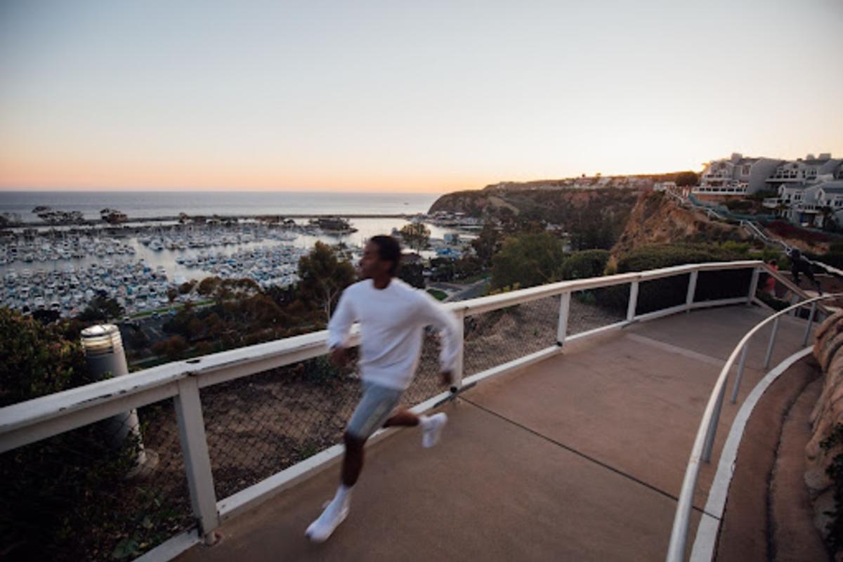 Man Running with ocean behind him at the Dana Point Bluff Top Trails