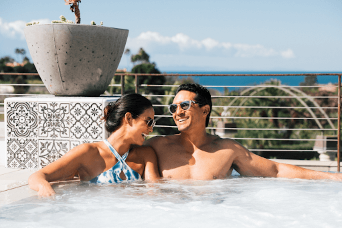 A couple relaxing in a hot tub overlooking the ocean at one of the world renowned Dana Point Hotels and Resorts 