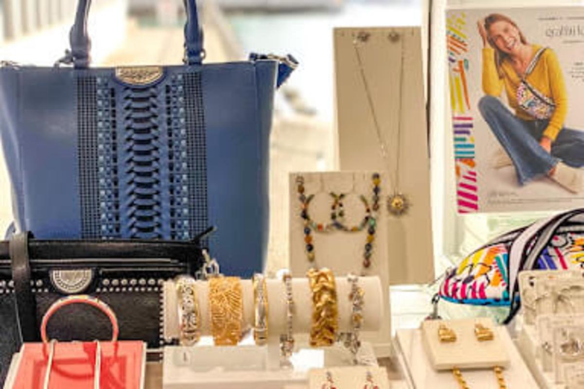 Purple purse and black clutch bag in the window display with assorted jewelry available at Golden Galleon Boutique 