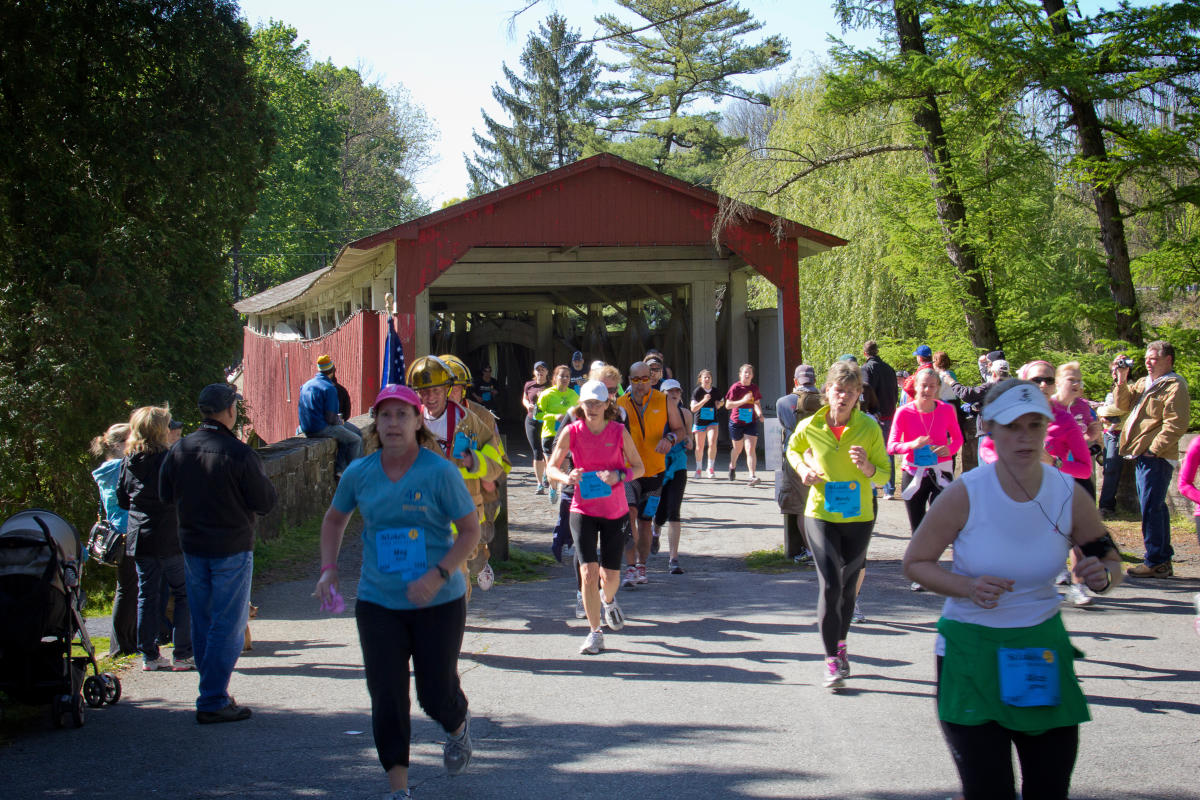 Runners at the St. Luke's Half Marathon run through a covered bridge in Lehigh Valley, PA