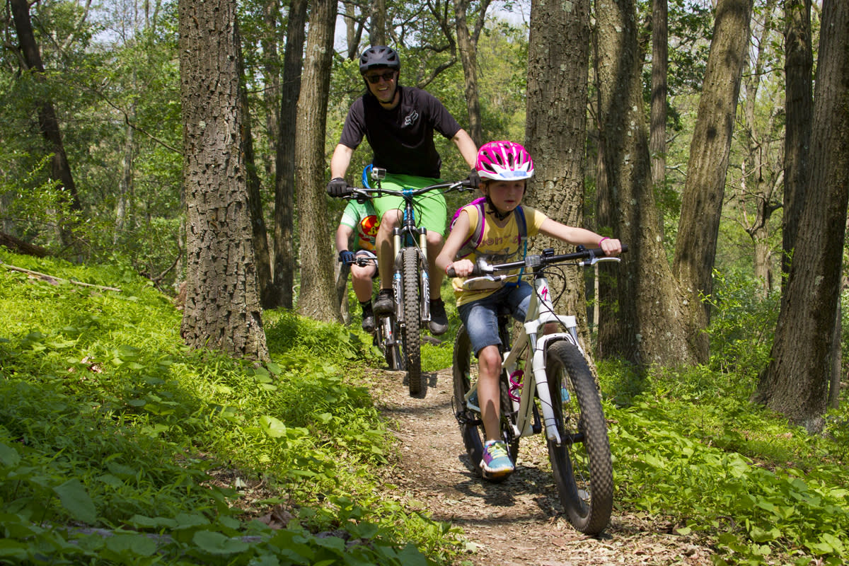 A kid and an adult ride mountain bikes through Trexler Nature Preserve in Lehigh Valley, PA