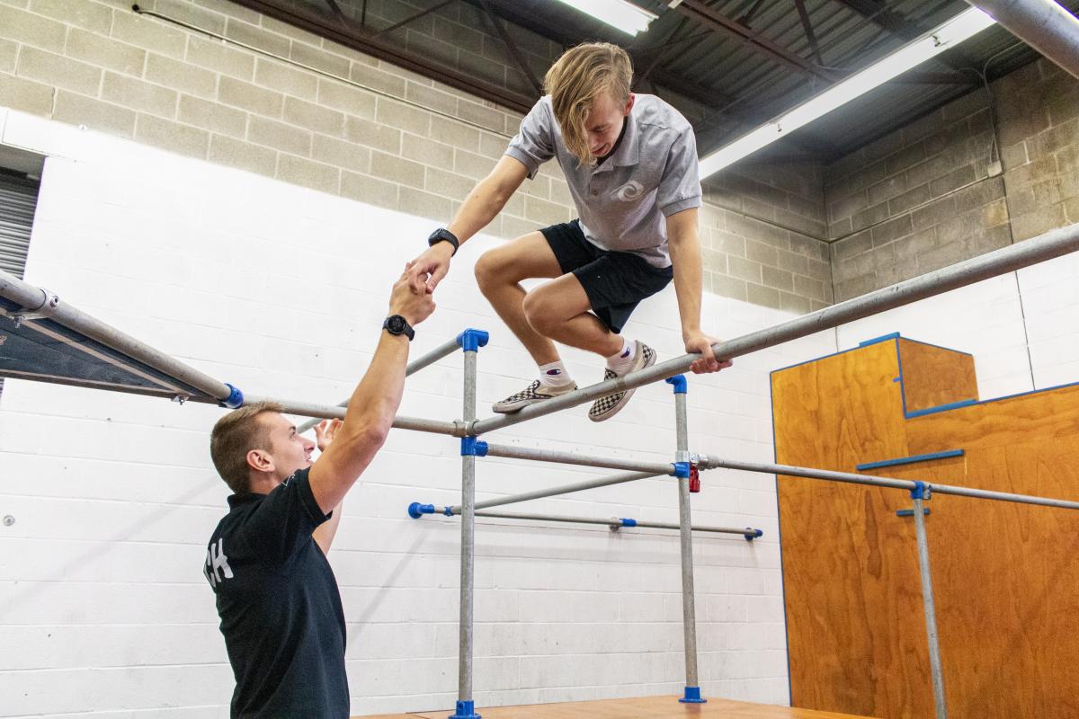 Parkour instructor guiding student through course at Lehigh Valley Parkour Academy