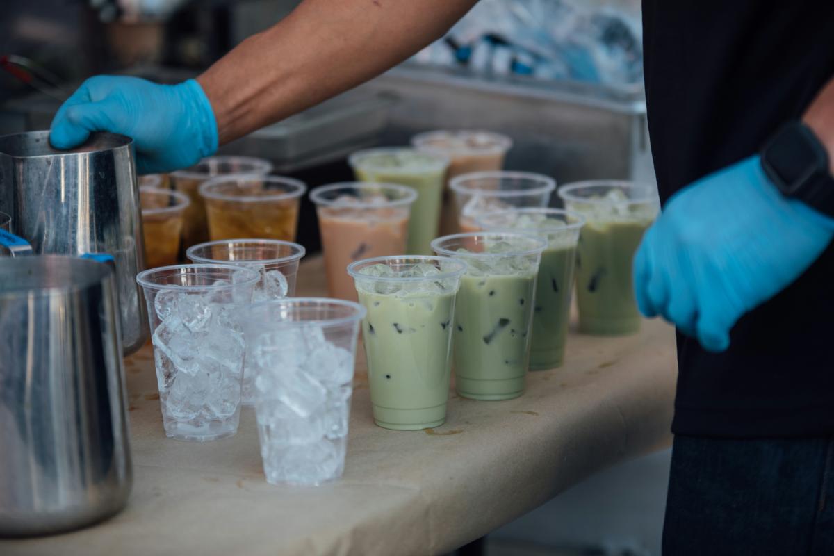 Worker fills up multiple cups with milk tea and boba pearls