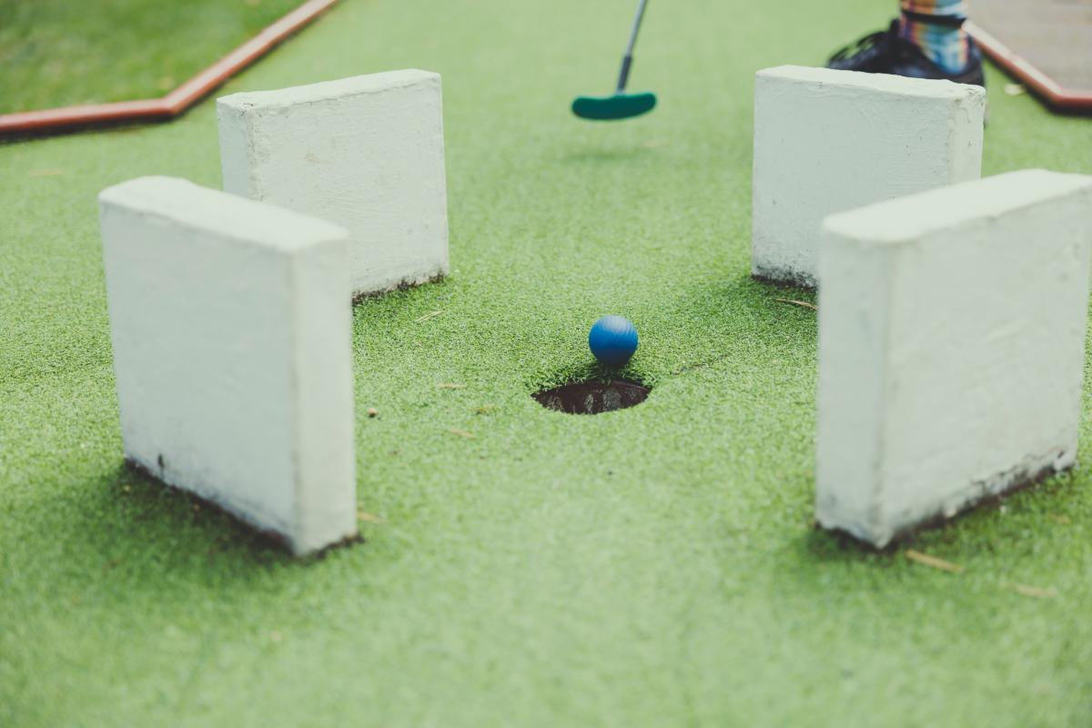 Mini Golf ball about to fall into hole