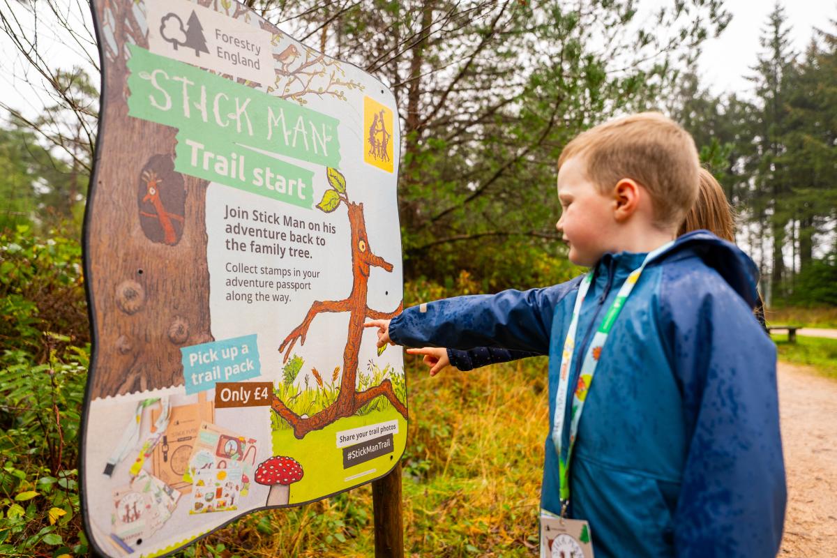 Boy looking at sign on the Stick Man Trail at Moors Valley Country Park and Forest