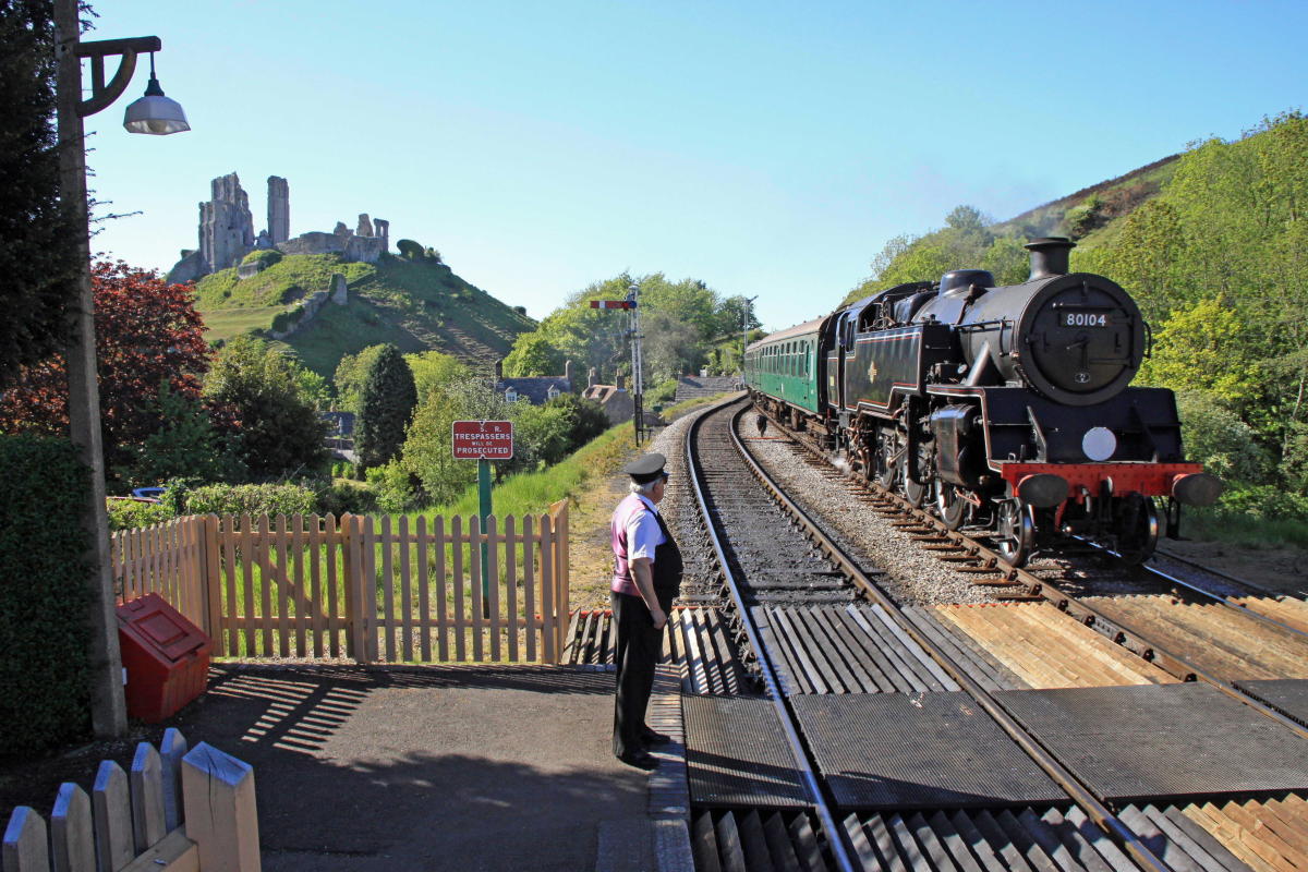 Swanage Railway guard standing on the platform at Corfe Castle Station, Dorset
