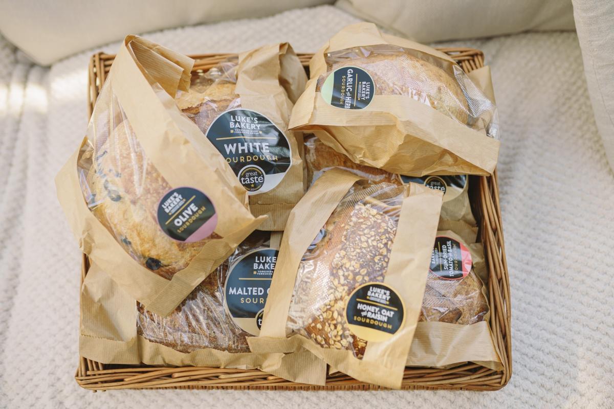 A selection of loaves styled in a basket from Luke's Bakery
