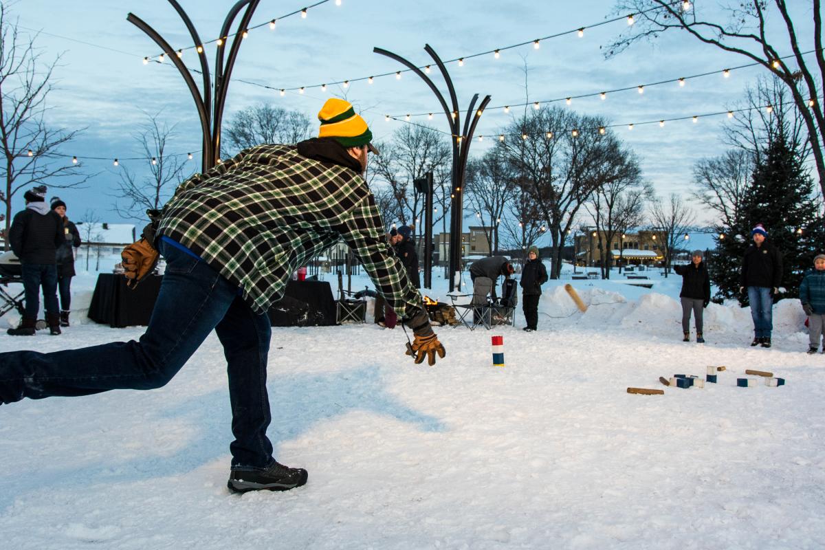 An action shot of people playing Kubb in River Prairie Park in Altoona