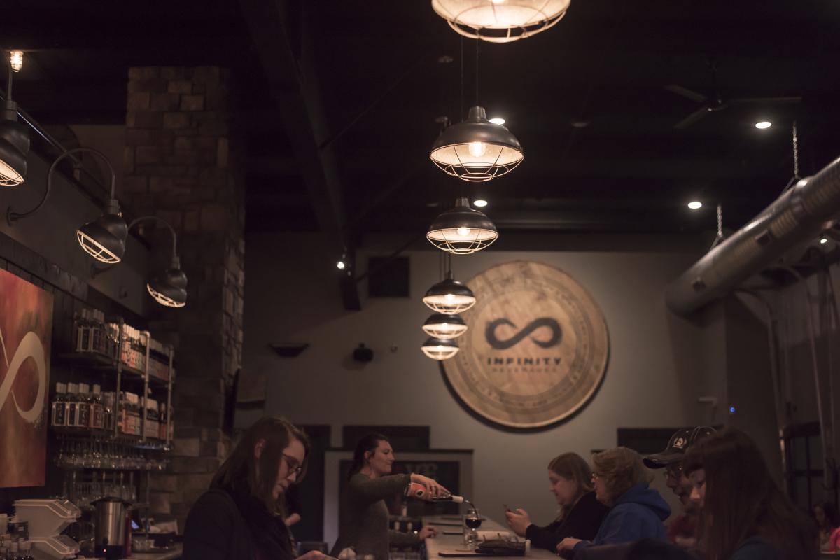 Bartenders pouring and mixing cocktails to patrons at Infinity Beverages Winery & Distillery