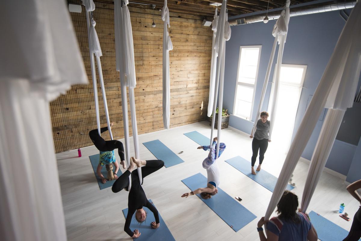Aerial view of people handing upside down at a Sky Yoga Studio Yoga Class