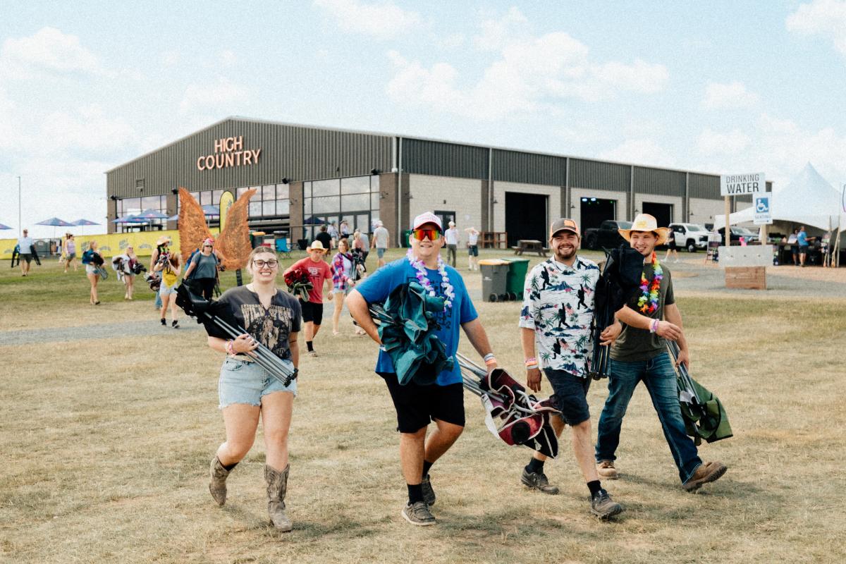 A group of fans carrying their lawn chairs into the festival grounds