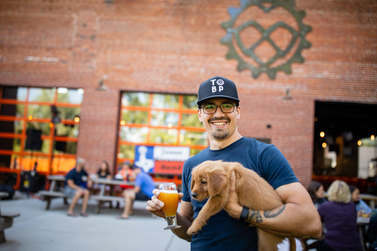 Owner holding his dog and a beer at the Brewing Projekt