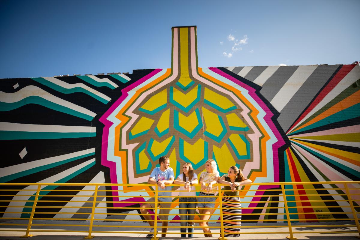 Friends standing in front of the mural at The Brewing Projekt