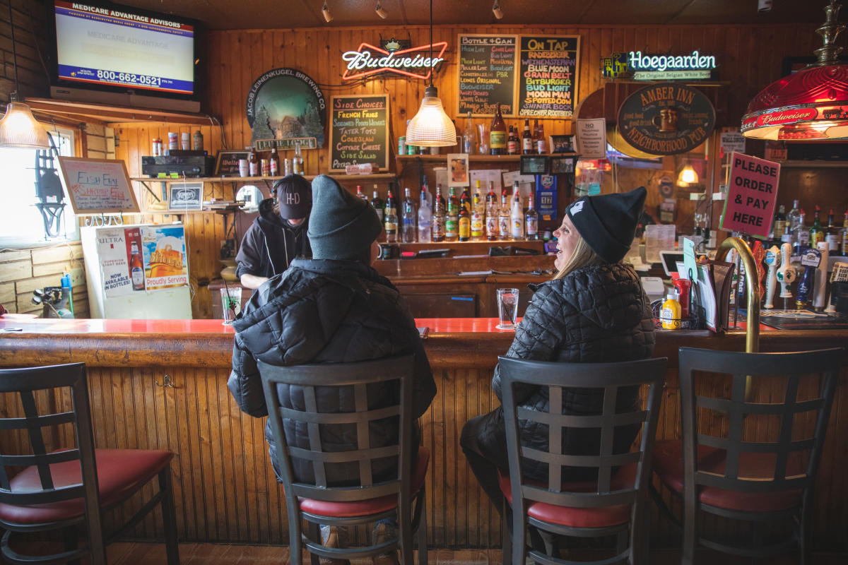 Two people sitting at the bar at Amber Inn