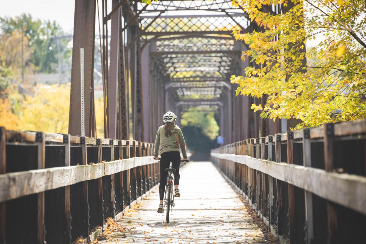 a girl riding her bike across a wooden bridge in Eau Claire