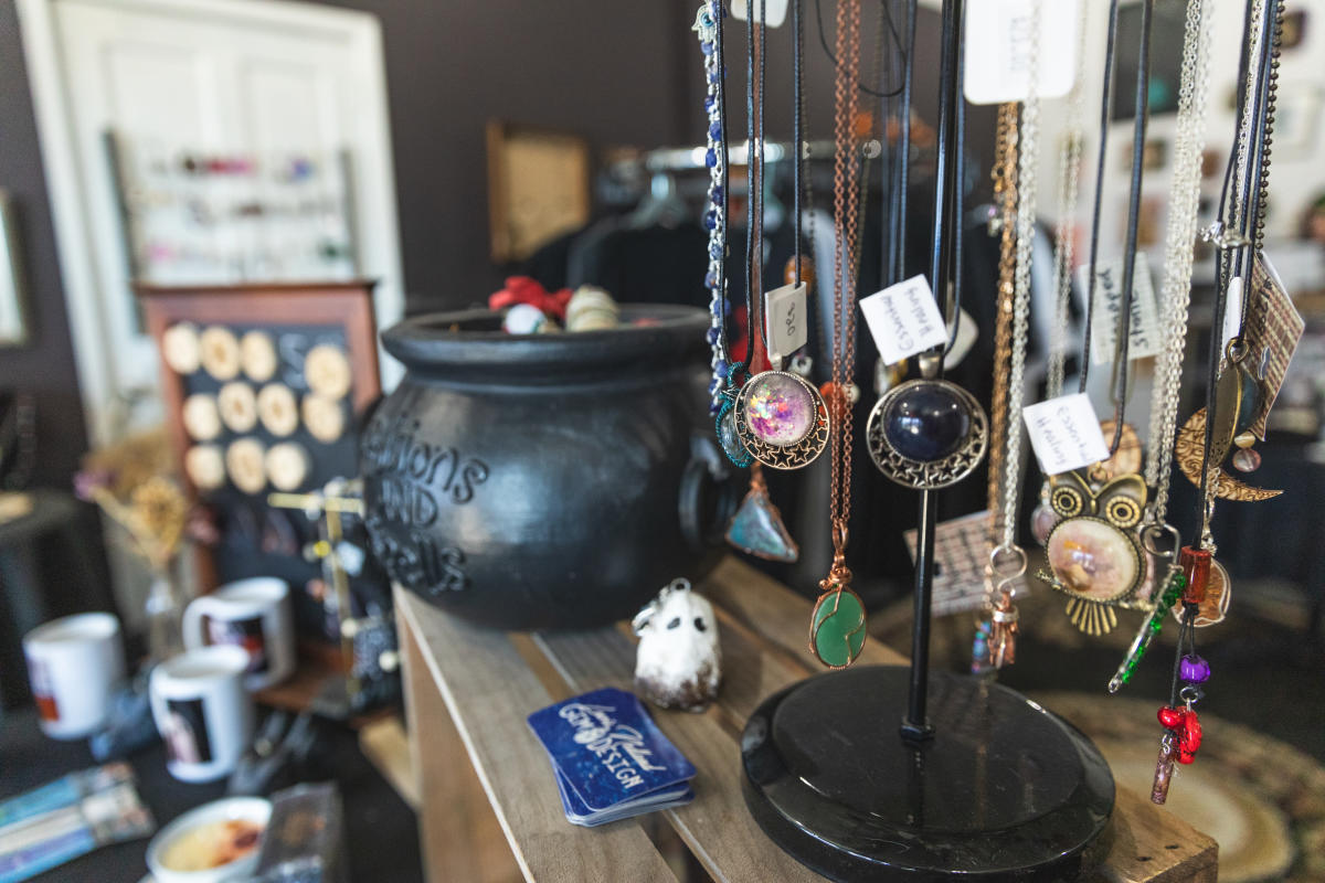 A photo of necklaces next to a black kettle at Black Kettle Tea Shop