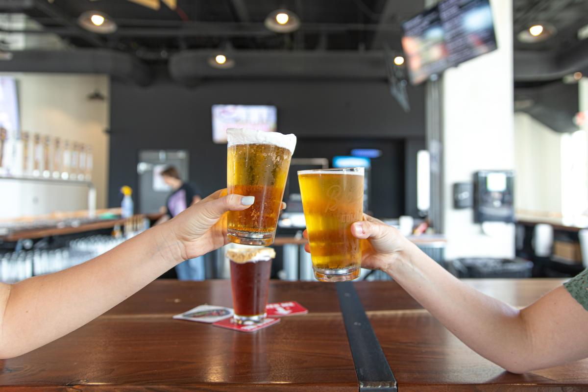Two beer glasses clinking together