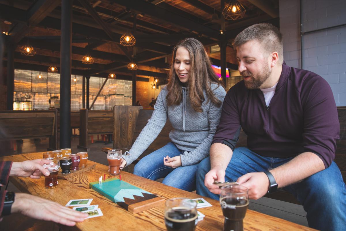 A couple drinking beers and playing cribbage at the Brewing Projekt