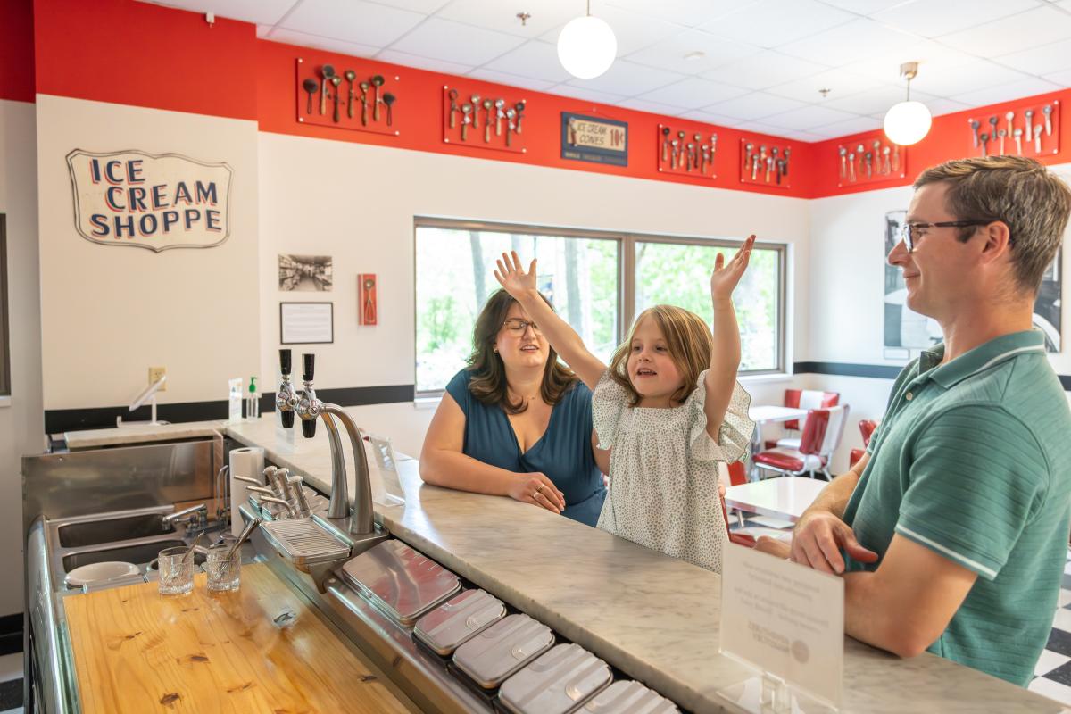 A mother, father and daughter at the serving counter of the Chippewa Valley Museum Ice Cream Parlor