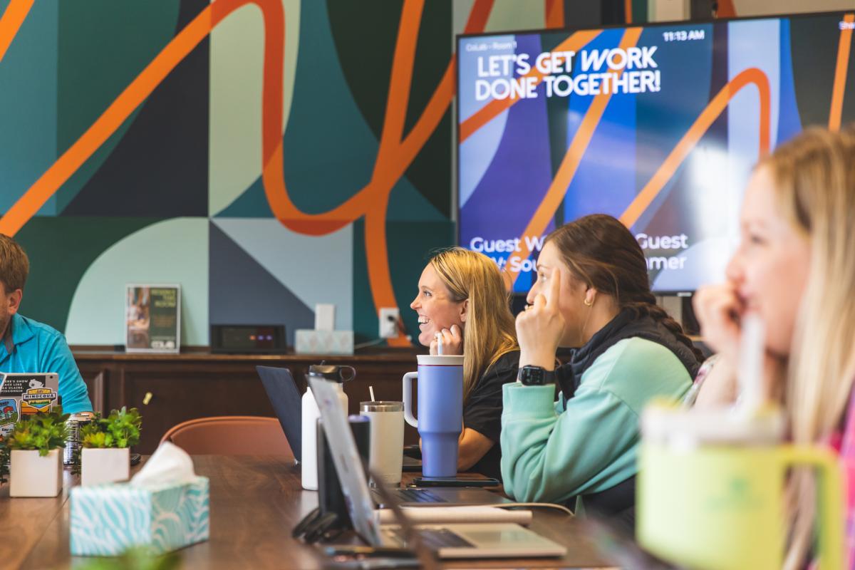 two women laughing and discussing in a conference room at CoLab in Eau Claire