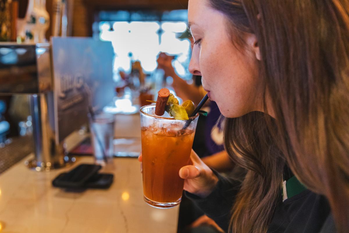 A girl sipping a Bloody Mary at Cowboy Jack's