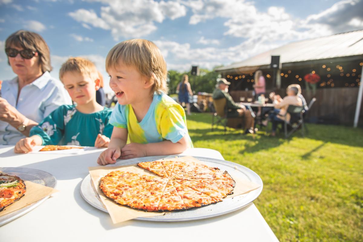 Young boys eating pizza at Dancing Yarrow pizza farm